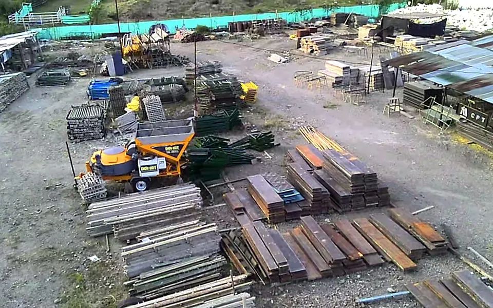 Vista aérea del centro de producción con formaleta, puntales y equipos ordenados en el patio